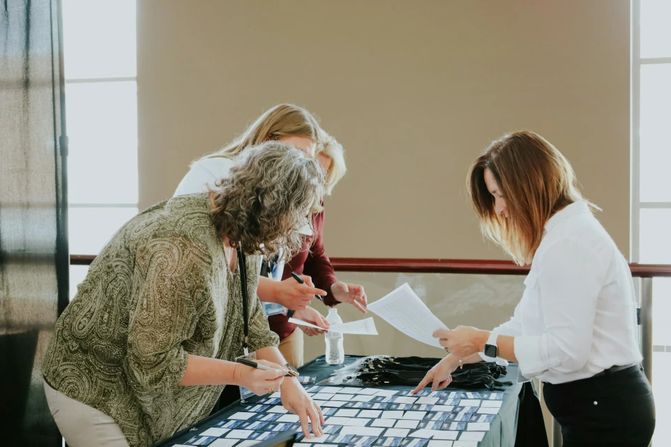 a group of women standing around a table with a keyboard